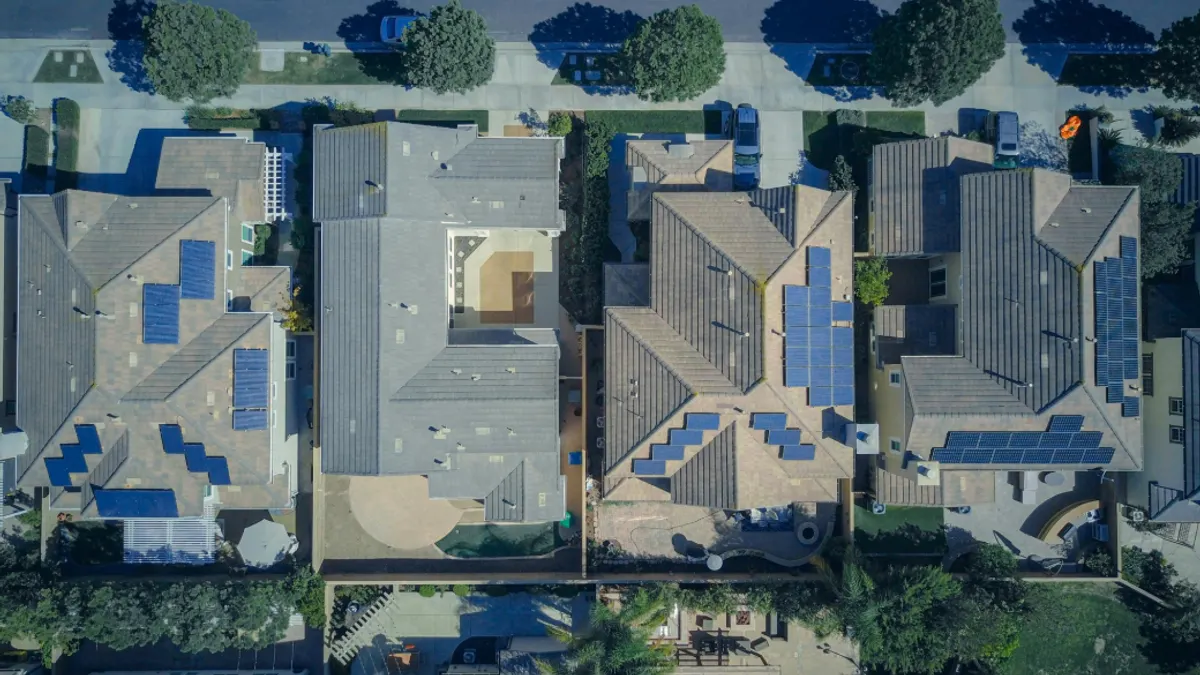 Overview shot of houses with solar panels on their roofs.