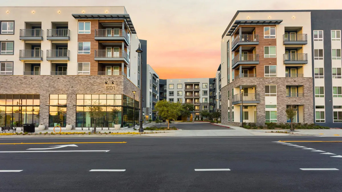 Brown and white mid-rise apartment community.
