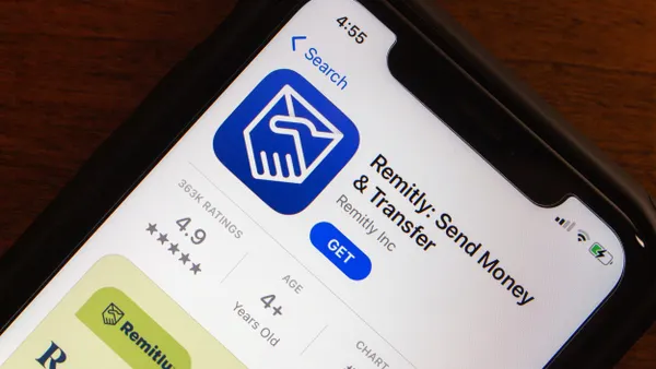 ​A close-up of an iPhone screen displaying the Remitly: Send Money & Transfer app's listing in the Apple App Store. The screen shows the Remitly logo, app name, and download option, highlighting the digital remittance service's presence on mobile platforms. 