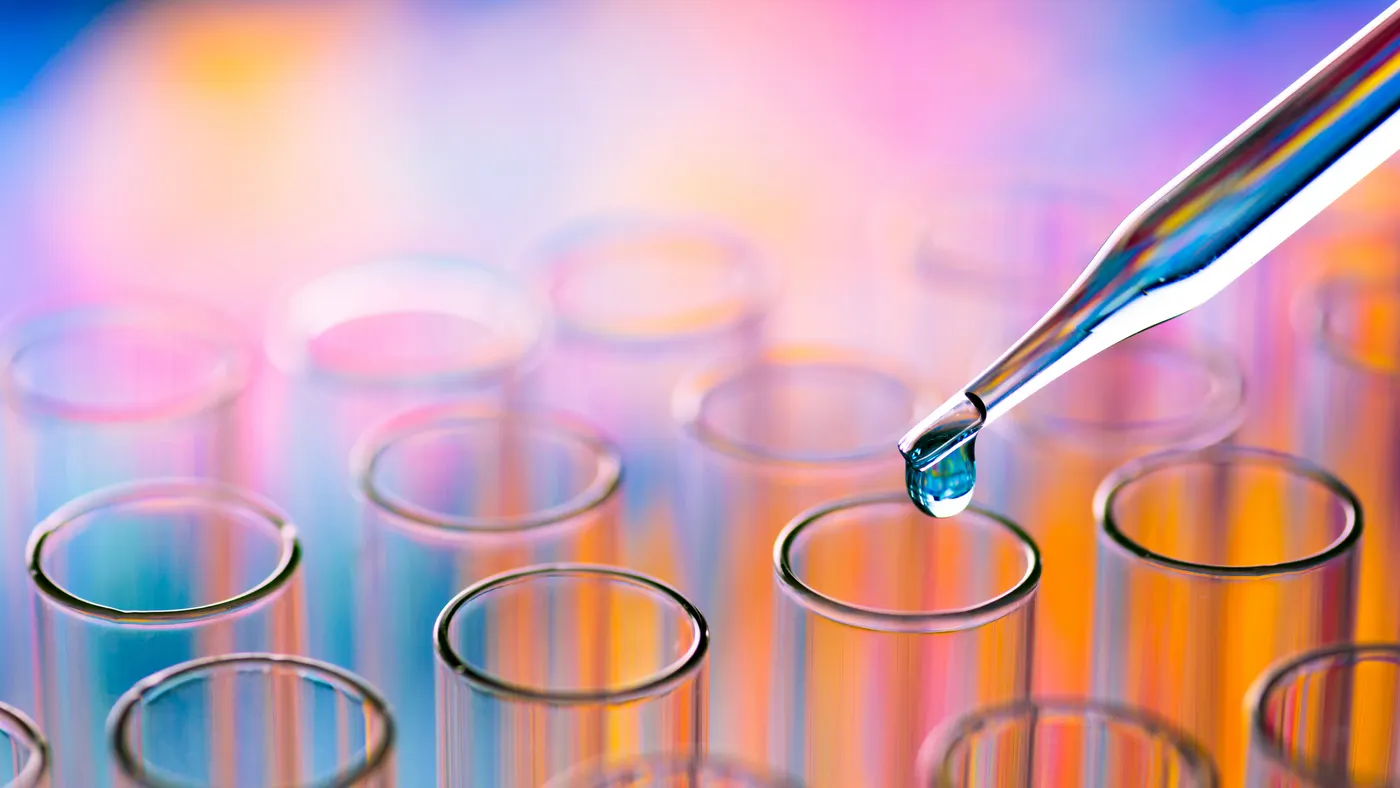 Close-Up Of Pipette Dripping Chemical In Test Tube At Laboratory