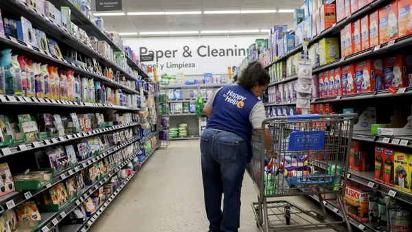 A person stocks shelves inside a Walmart retail store.