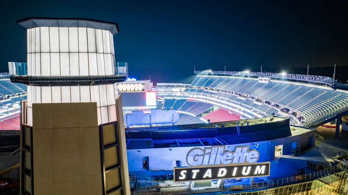 A tall, lit mock-up of a lighthouse in a football stadium. The photo is at night and the stadium is lit up.