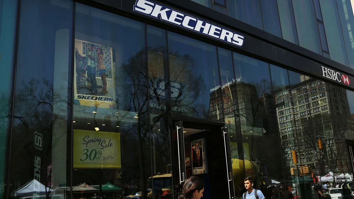 People walk past a Skechers storefront.