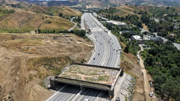An aerial view of members of the media and project partners visiting the construction site of the Wallis Annenberg Wildlife Crossing