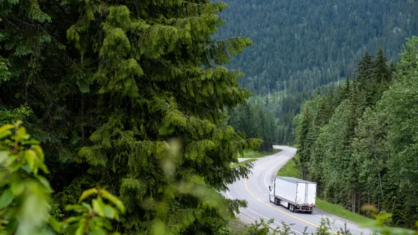 Large container truck driving along a highway.