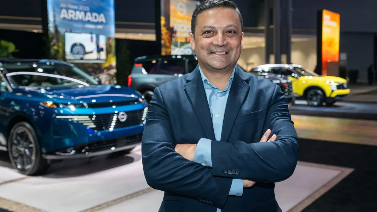 Ponz Pandikuthira, Nissan Americas Senior VP, at an auto show stand