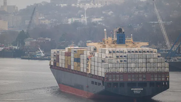A container ship shown on the water, departs an ocean port in New York.