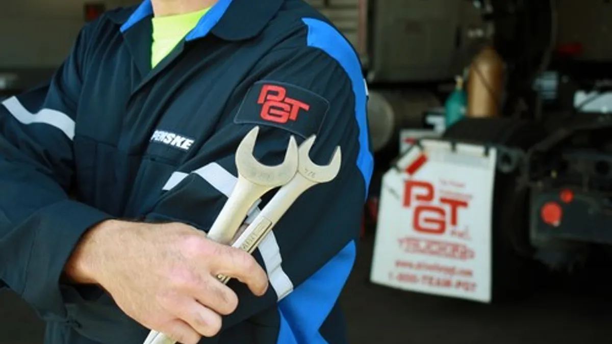 A maintenance tech holds two wrenches.