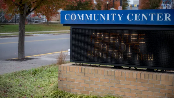 A digital sign outdoors announces absentee ballots are available.