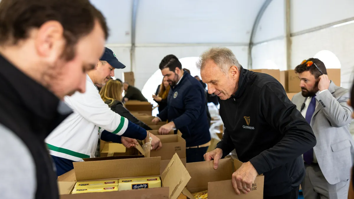 A group of people open cardboard boxes.