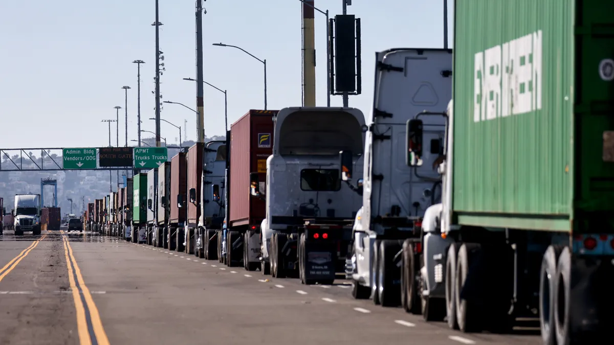 A line of tractor-trailers is seen on a road at the Port of Los Angeles.