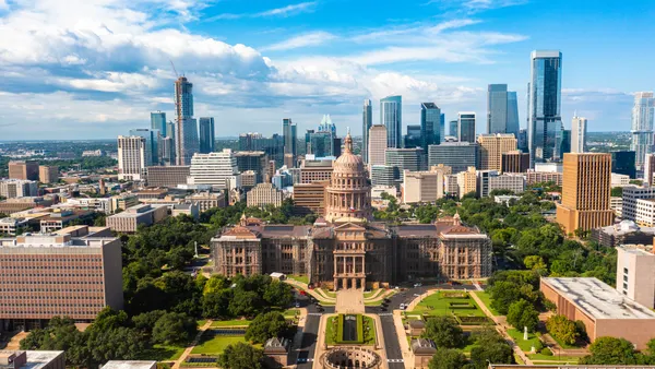 A skyline shot of Austin, Texas, with its skyscrapers, and with the Texas State Capitol building in view.
