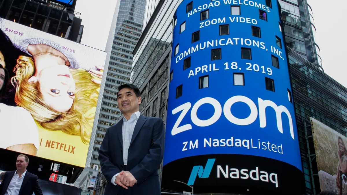 Zoom founder Eric Yuan poses in front of the Nasdaq building as the screen shows the logo of the video-conferencing software company Zoom after the opening bell ceremony on April 18, 2019 in New York