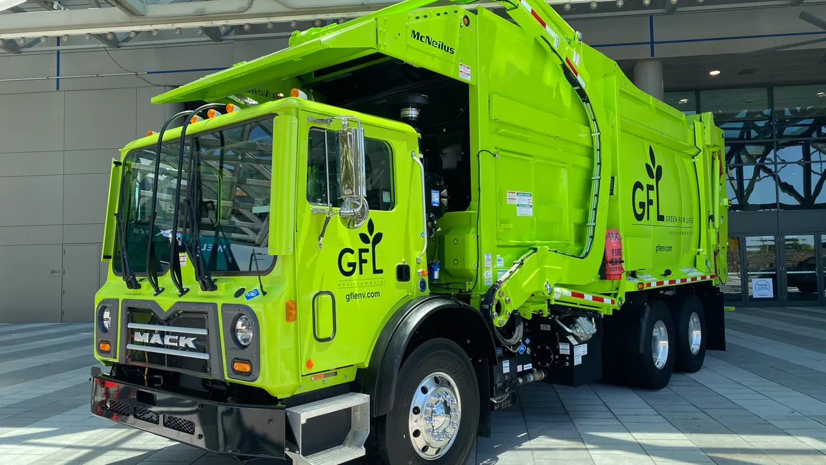 A demonstration hauler with GFL's logo outside a conference center