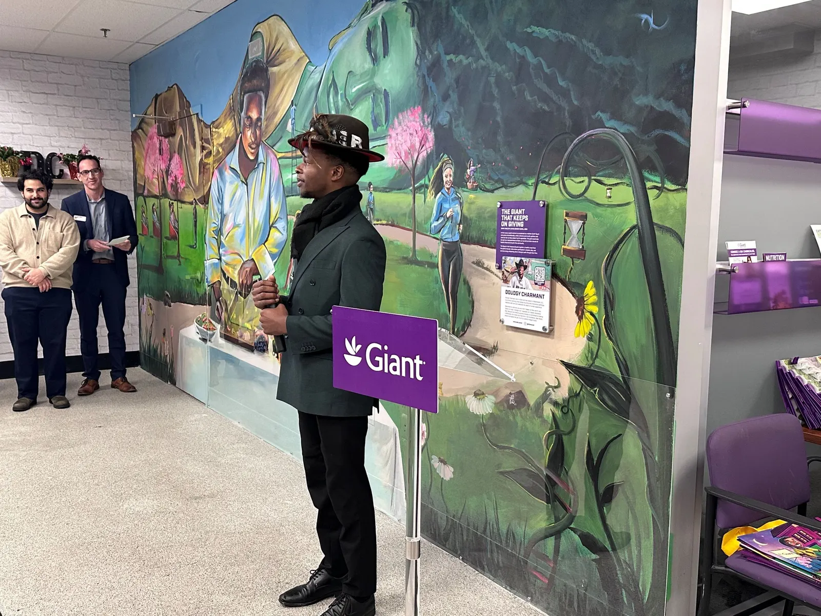 Artist standing in front of his newly debuted mural