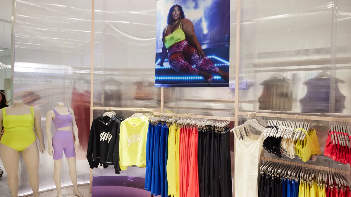 Multi-colored clothing on metal and white racks in a store