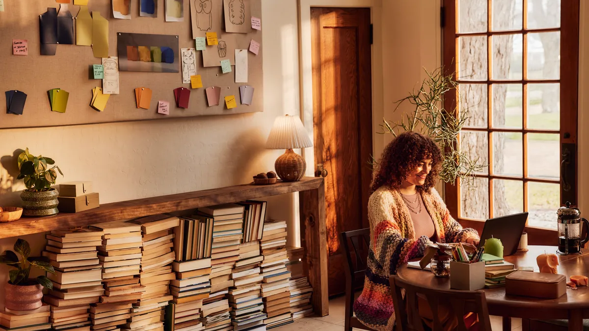 A women sits at the computer in her home.