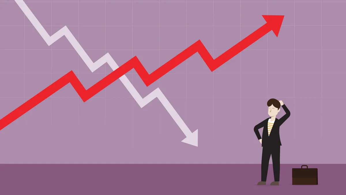 A businessman looks at a stock market graph