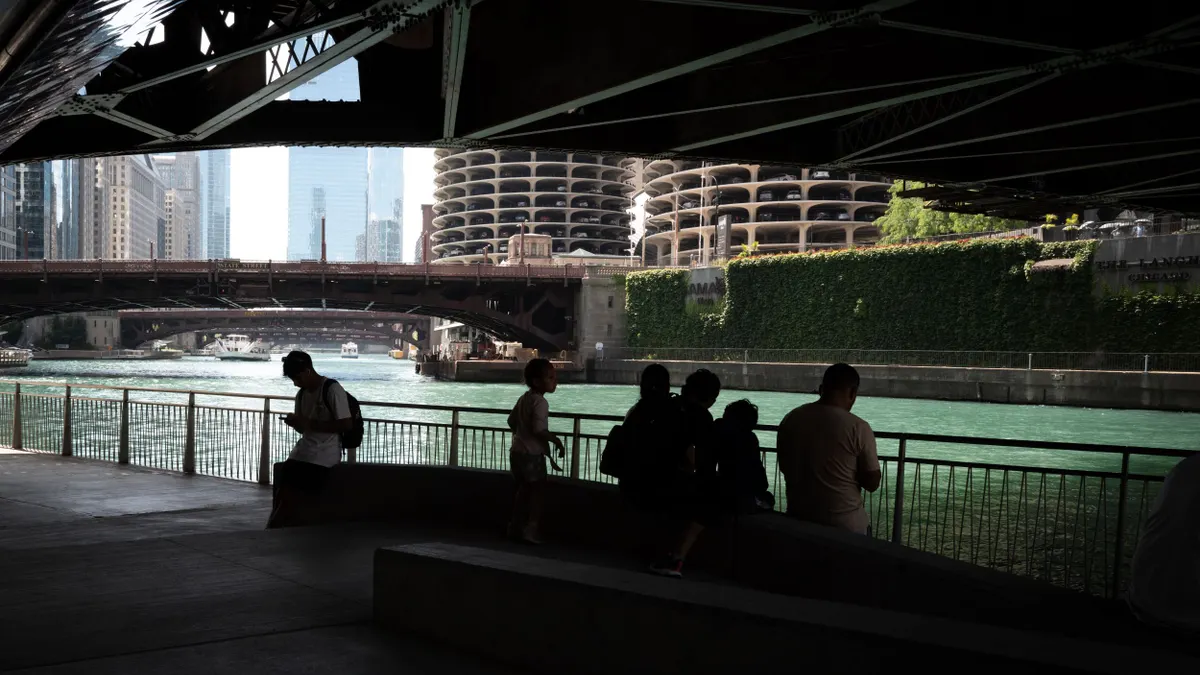 People cool off in the shade of a bridge along Chicago's Riverwalk