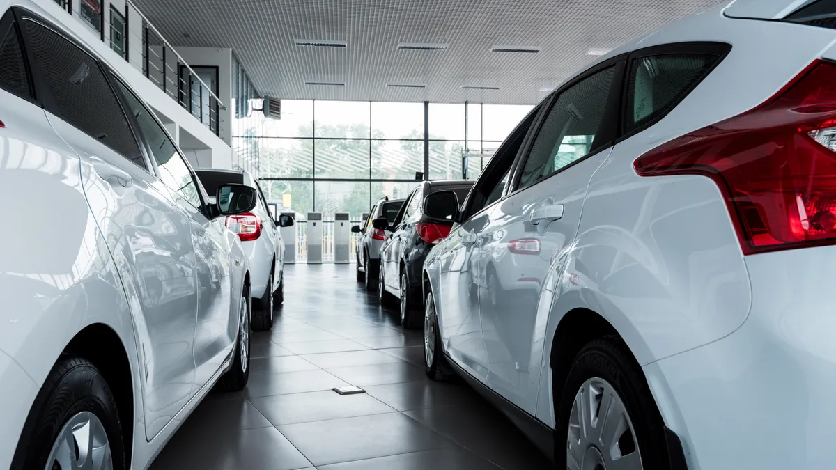 A showroom of a dealership featuring several cars.