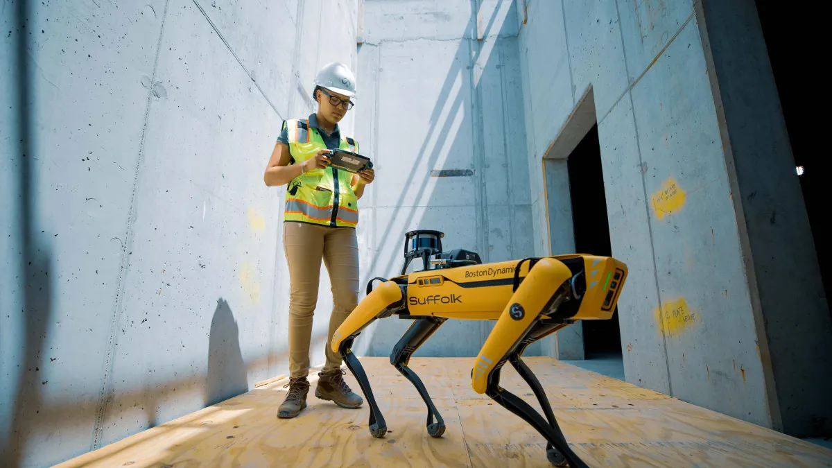 A worker manipulates the quadripedal Spot for Suffolk Construction