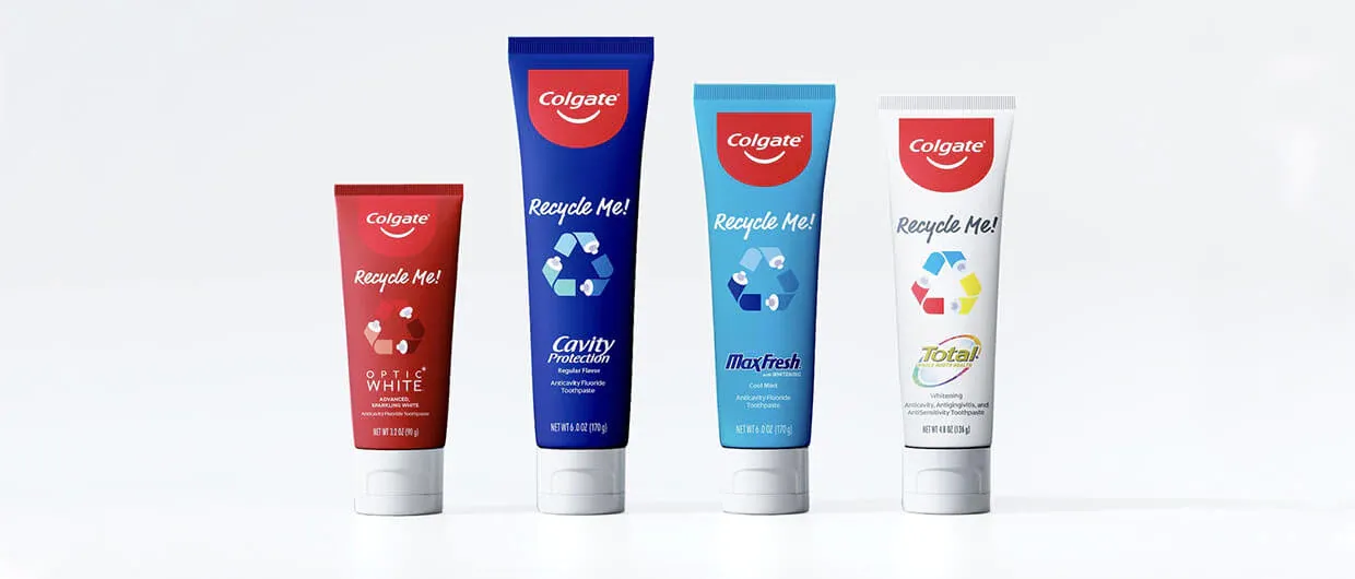 Four different colored tubes of Colgate toothpaste with the message &quot;Recycle Me!&quot; printed on the tubes.