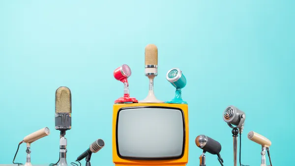 Retro microphones for press conference or interview and old TV on table front gradient aquamarine background