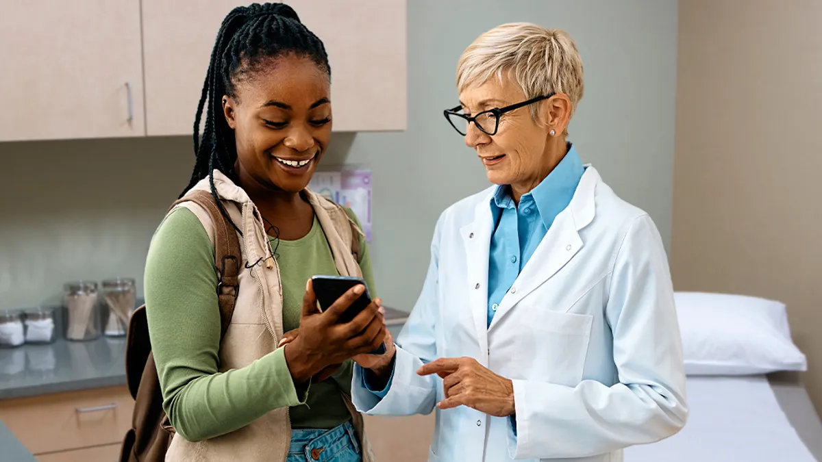 Female patient and Doctor looking at mobile device