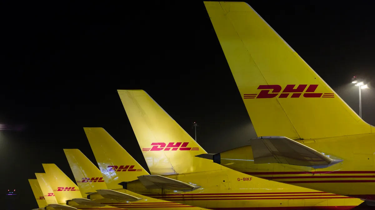 DHL cargo planes sit on the tarmac.