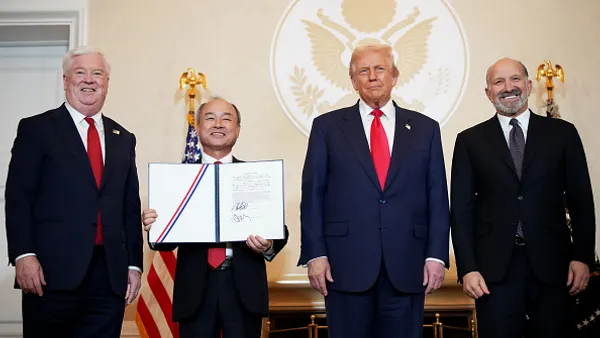 A group of four men pose for a photograph.