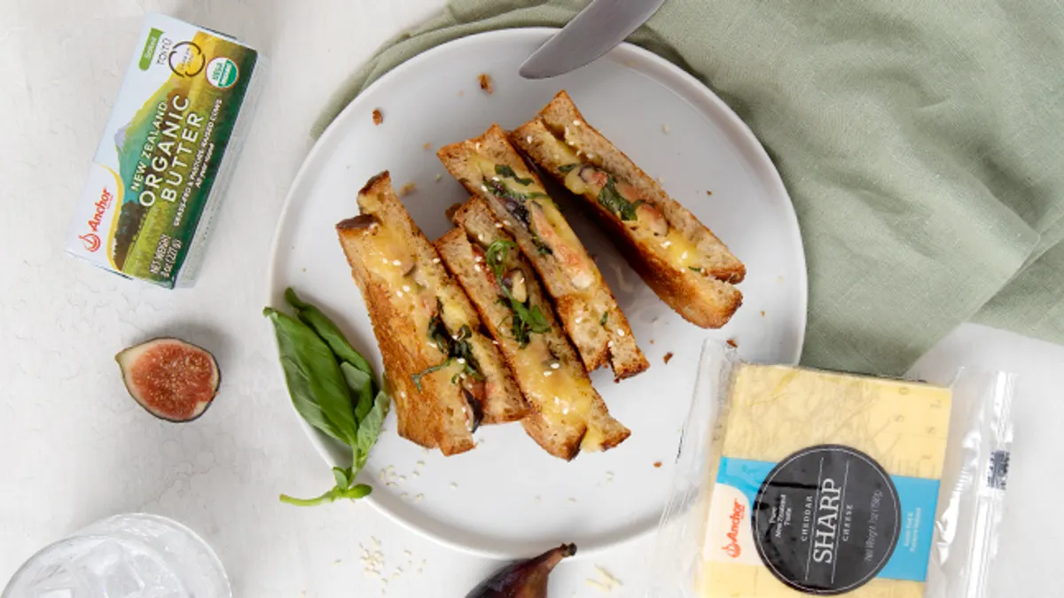 Grill cheese slices lined up on a white plate.