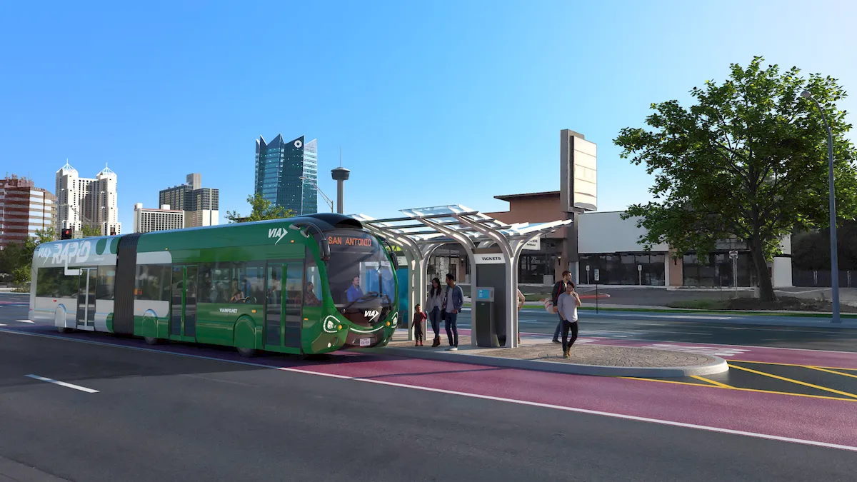 A green bus on a red-painted lane stands in front of a modern stop.