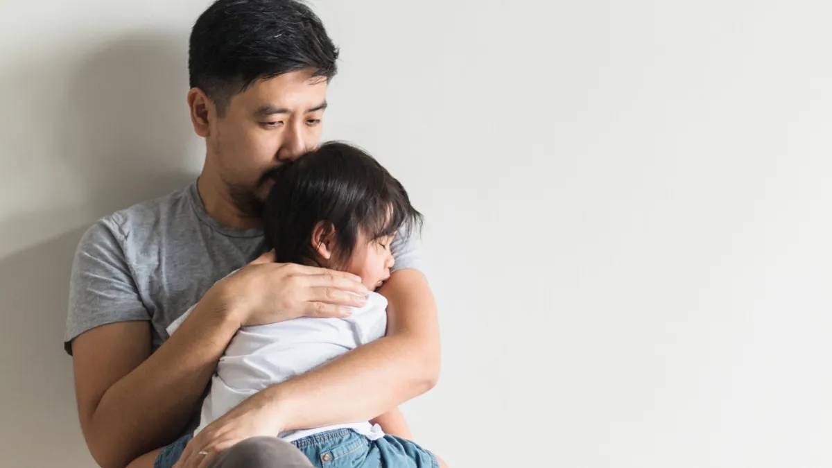 A parent holding their child.