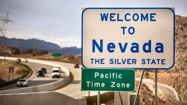 Entrance greeting sign on the highway border between Nevada and Arizona