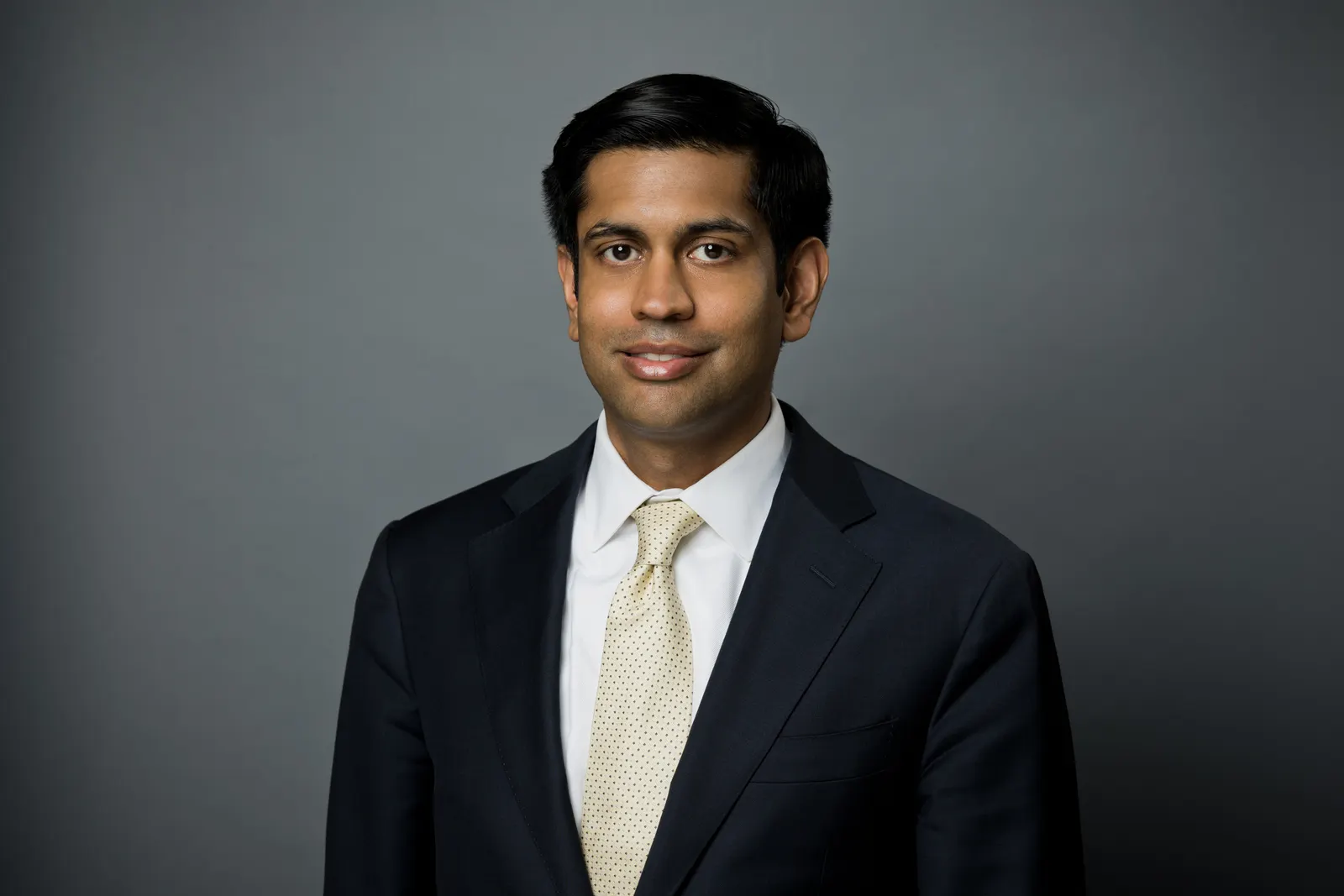 Badri Sridhar, a managing director with FTI Consulting, poses for a photo wearing a suit and tie