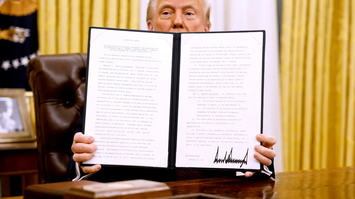 Trump holds up a signed executive order on issues including crypto and AI on Jan. 23, 2025.