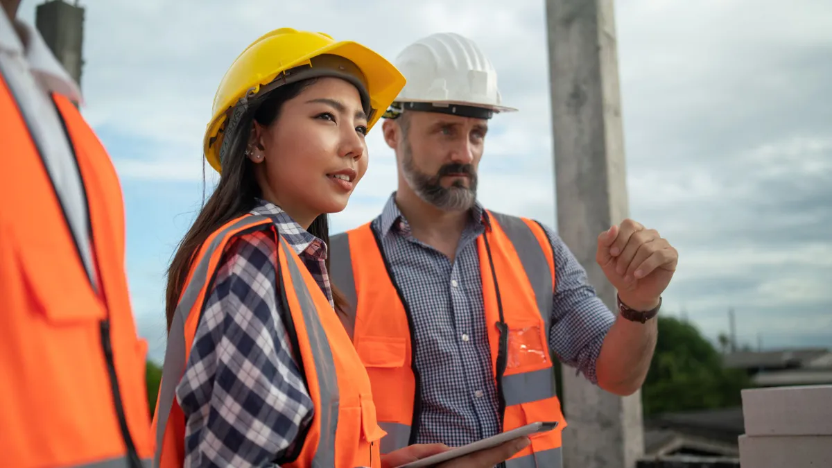 Two construction workers wearing safety hats.