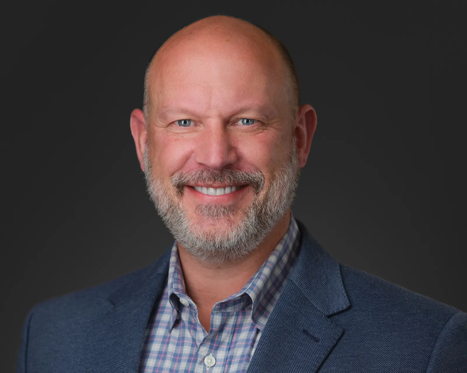 A head and shoulders photo of a person against a gray background.