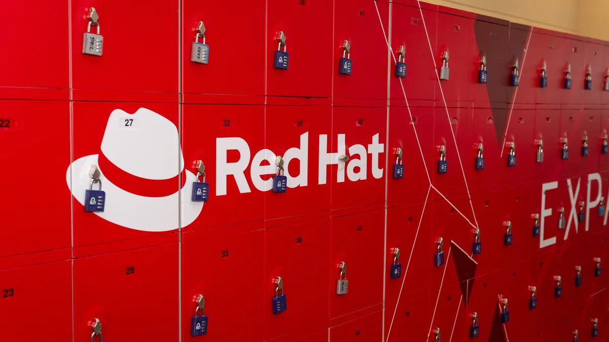 A stack of red lockers with a hat icon and the words "Red Hat" emblazoned in white on several of them