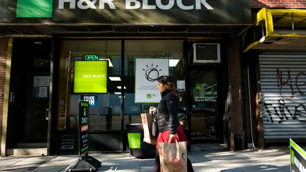 A woman walks past an H&R Block office.