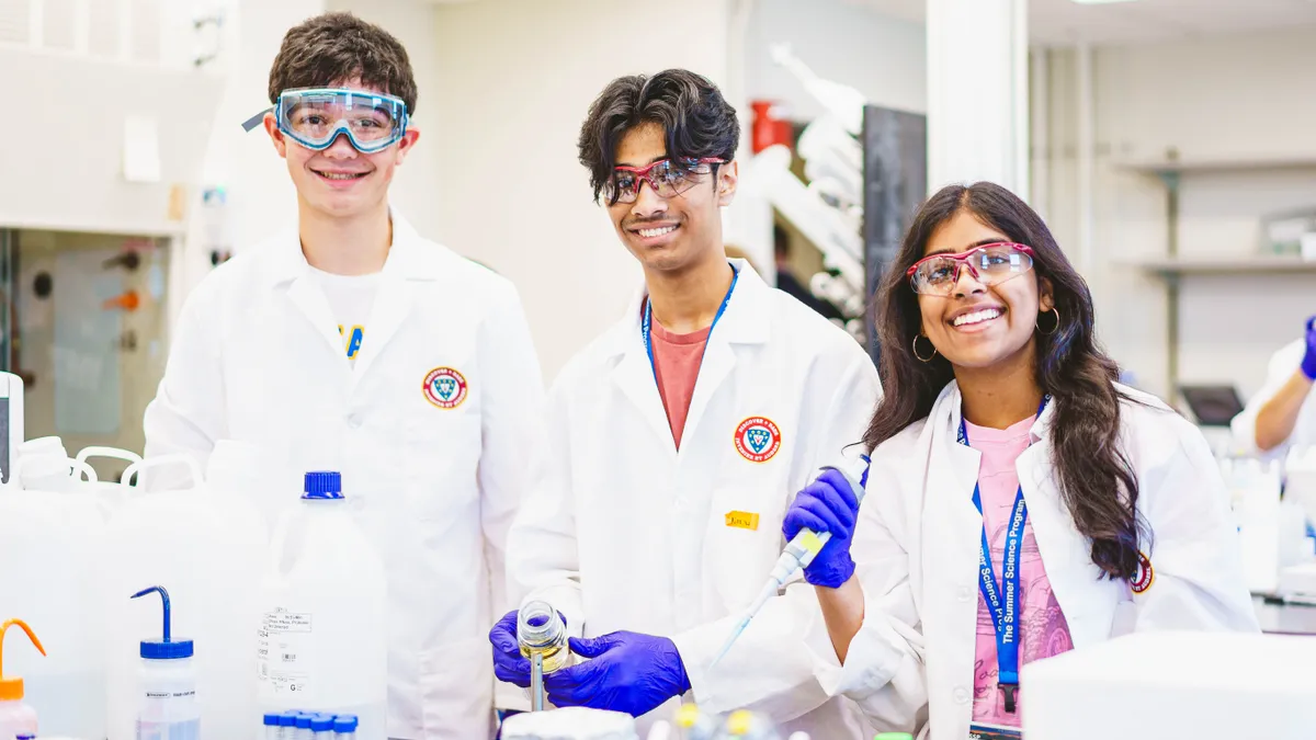 3 science students in a lab smiling