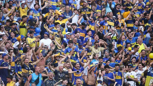 Fans in yellow and blue cheer on their team.