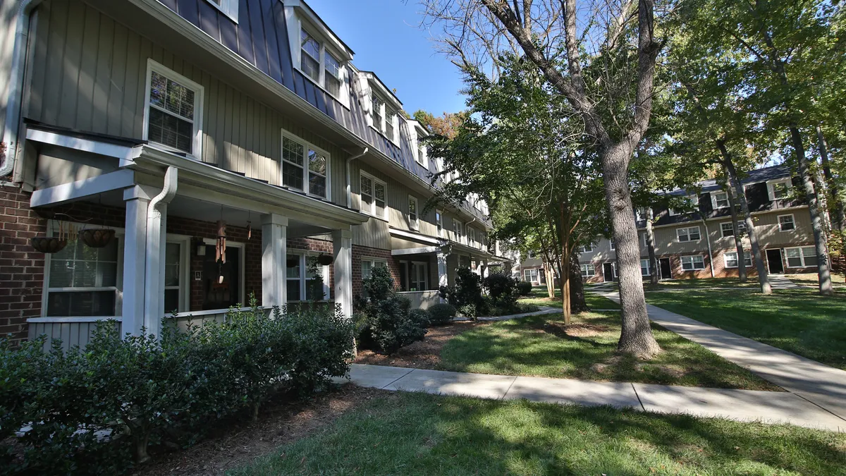 An an apartment building with trees in front.