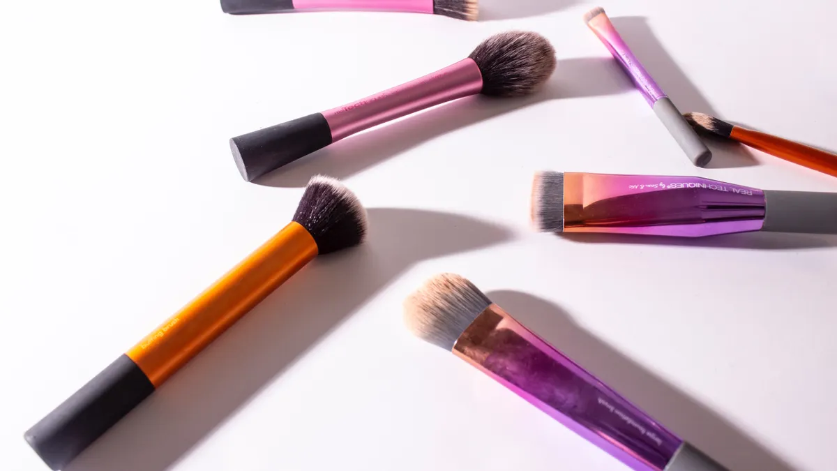 A number of makeup brushes askew on a white background.