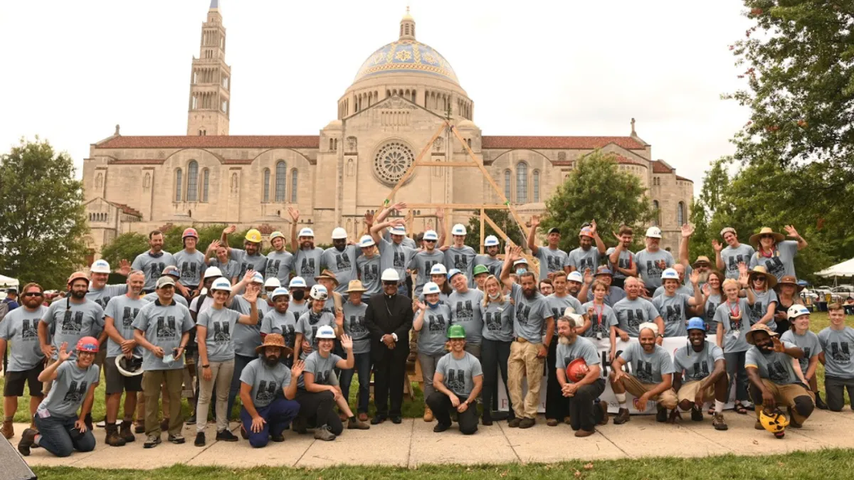 A handbuilt truss for the Notre Dame Cathedral stands in relief to the basilica on Catholic University's campus.