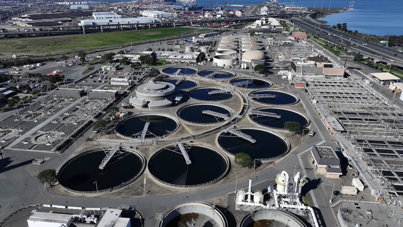 A sprawling water treatment plant on the shore of a large body of water.
