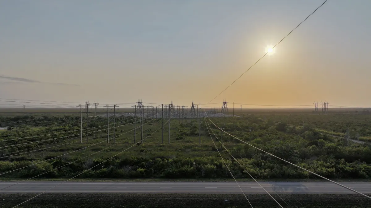 In an aerial view, high voltage power lines run through a sub-station