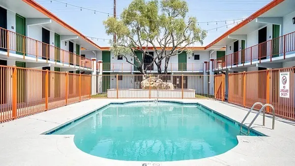 Pool surrounded by older apartment building