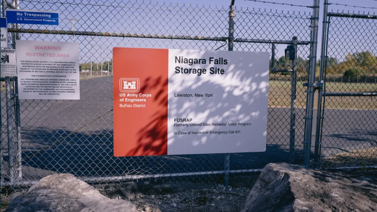 A sign on a chain-link fence in front of a concrete area marks it's owned by the U.S. Army Corps of Engineers, Buffalo District, and is part of the Formerly Utilized Sites Remedial Action Program