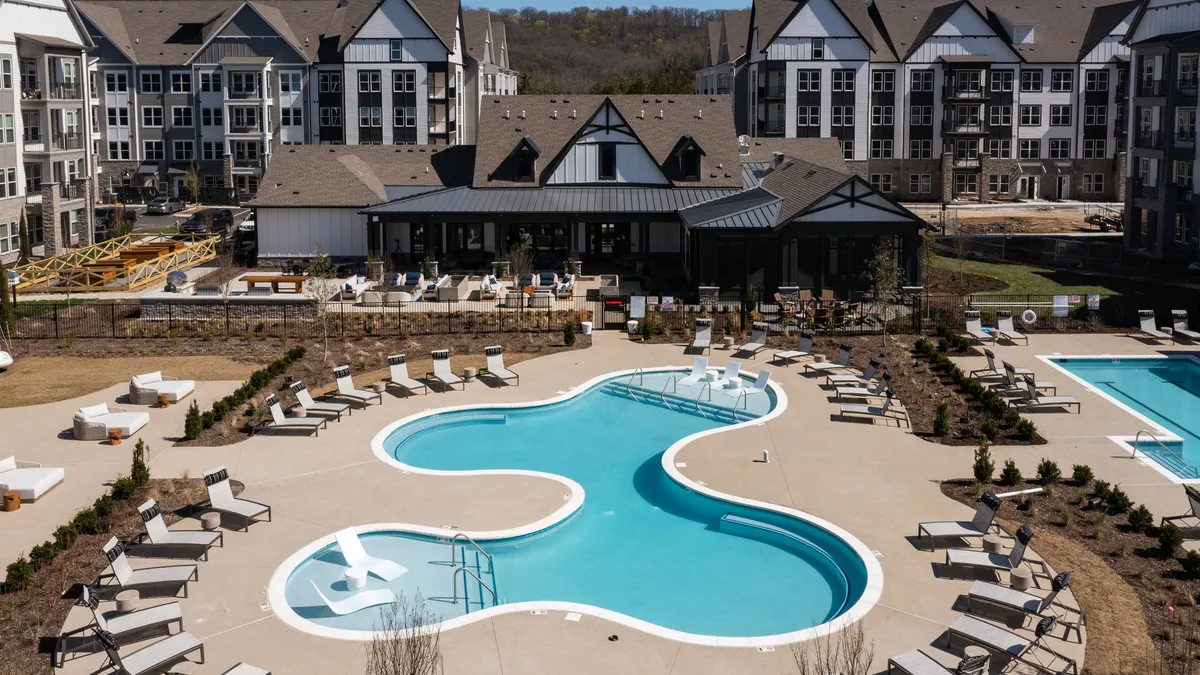 A mid-rise apartment building with a pool.